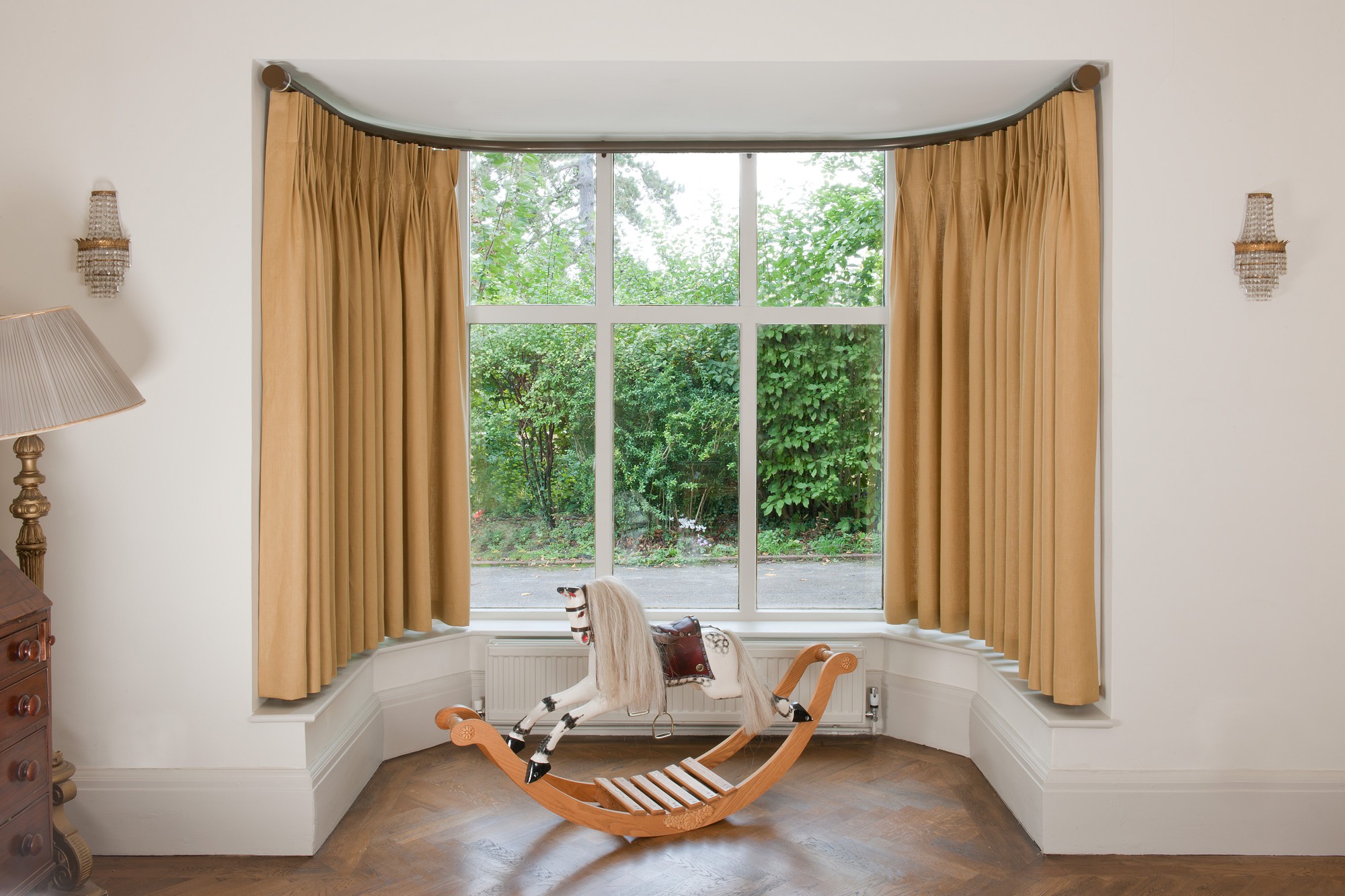 Bay curtain pole with curtains hanging